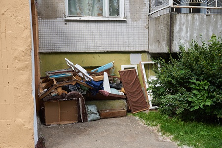 A Large Pile Of Rubbish Under The Windows Of A House